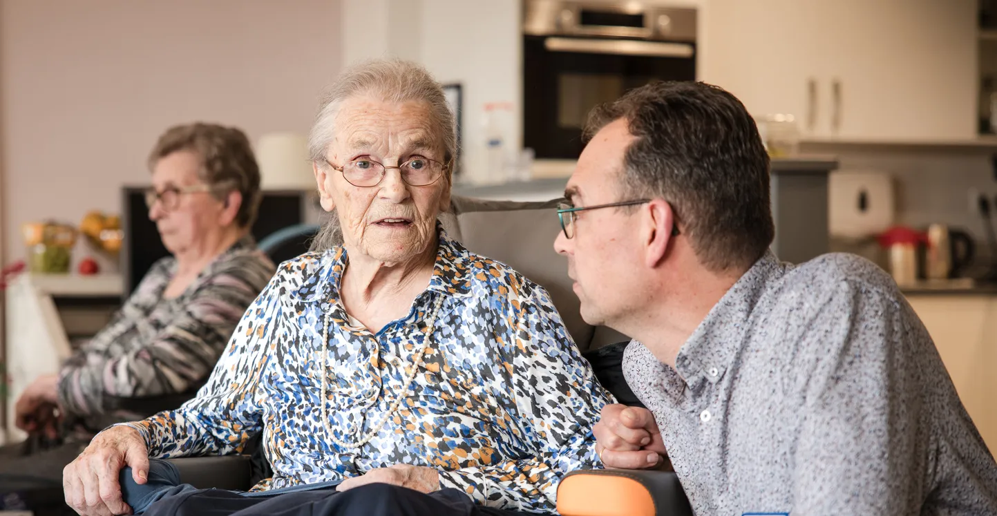 geestelijk verzorger praat met bewoner