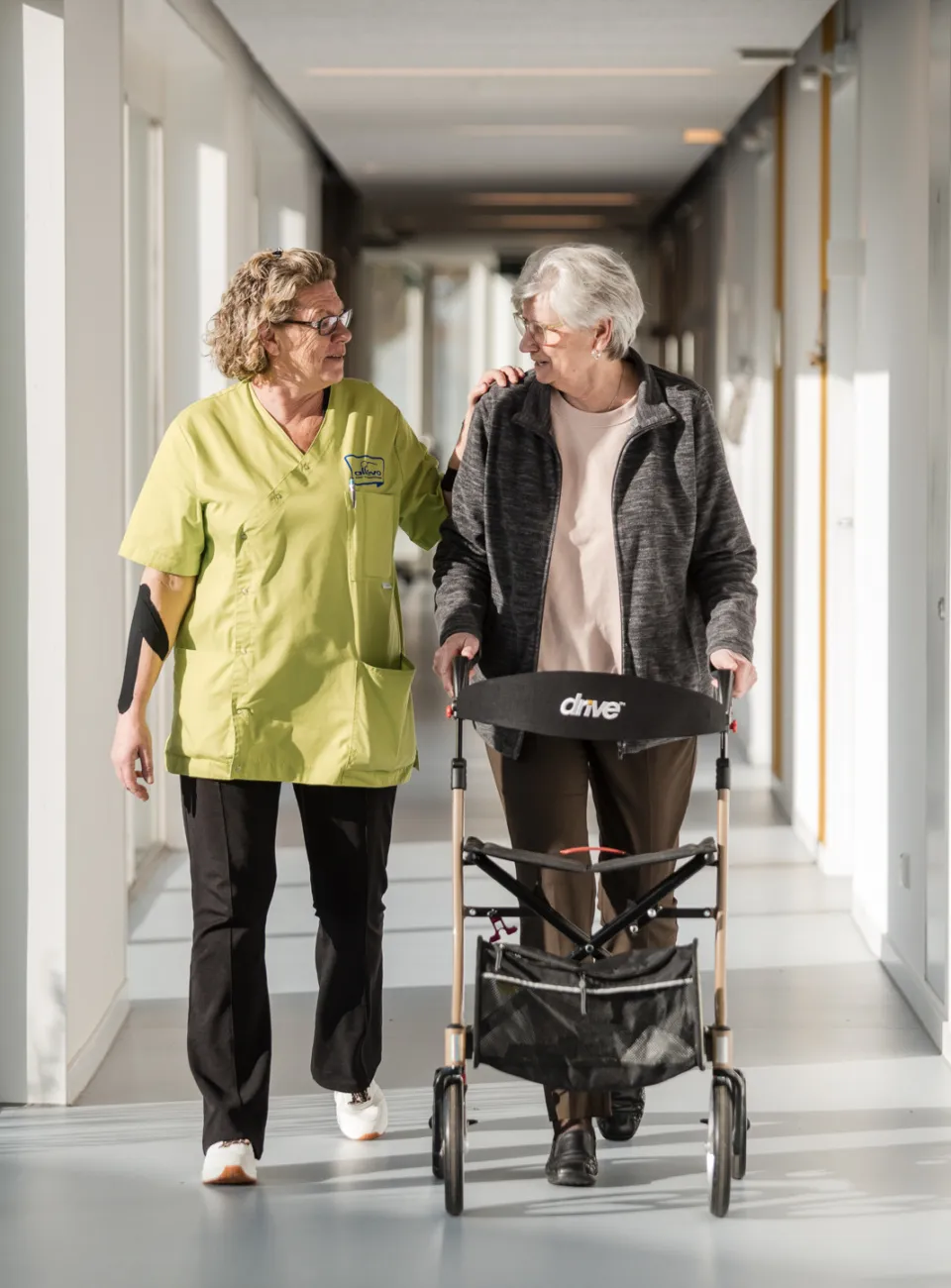 medewerker wandelt met cliënt met rollator door de gangen van Zierik7 verwijzers
