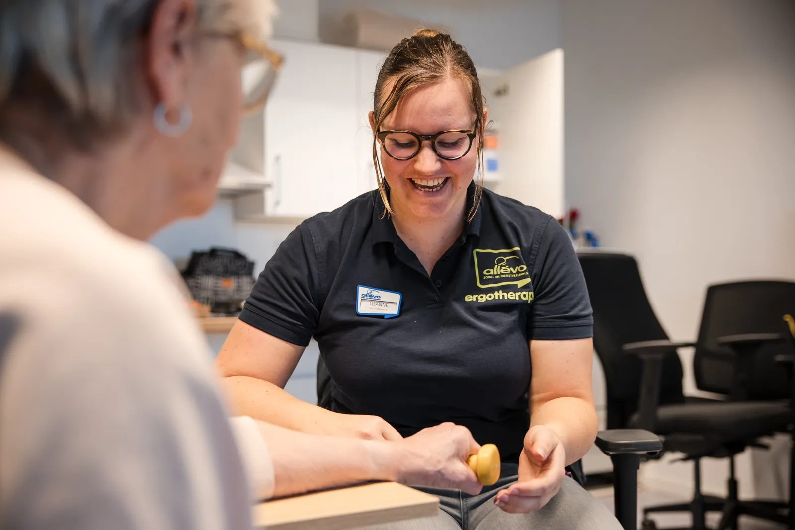 ergotherapeute voert handoefening uit met client