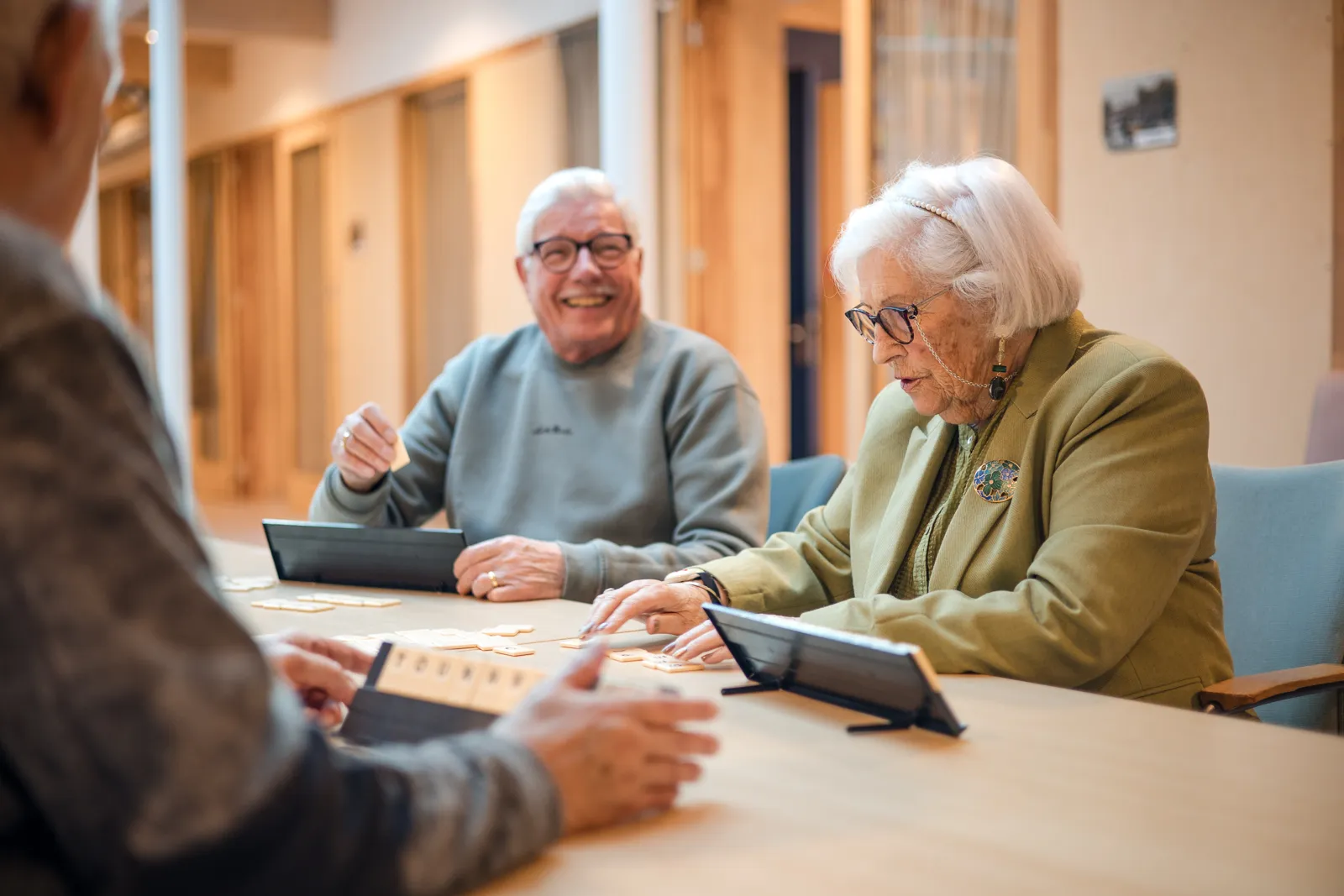 vrijwilligers spelen een spelletje met bewoners