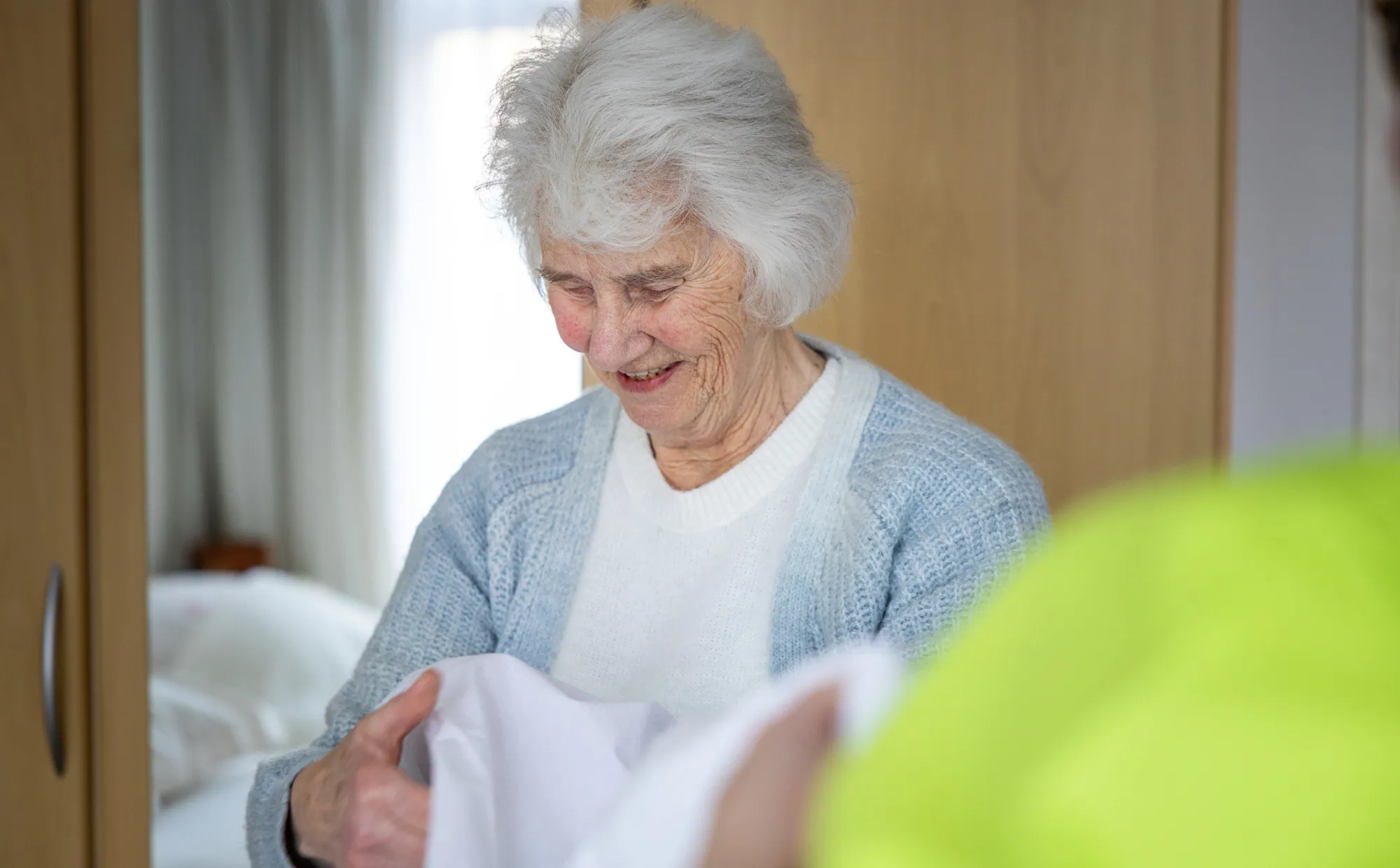 Cliënt vouwt de was op samen met de zorg aan huis collega