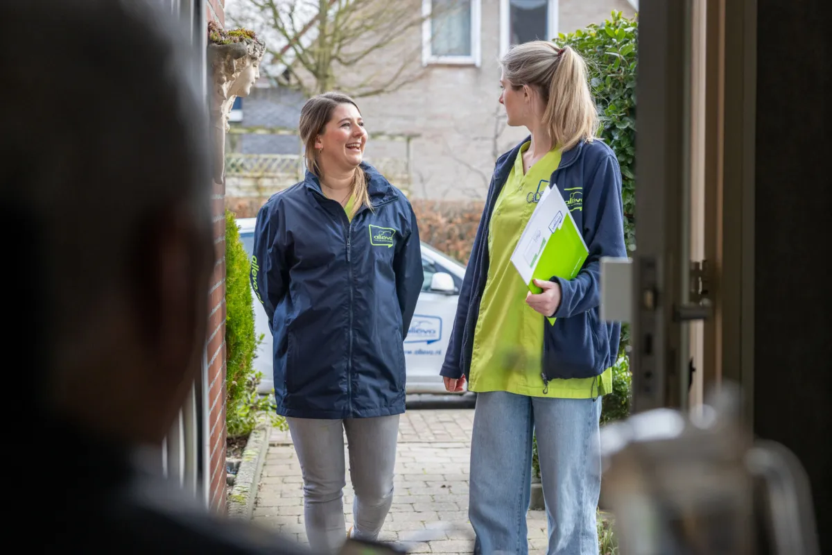 Thuiszorg medewerkers kijken elkaar aan.