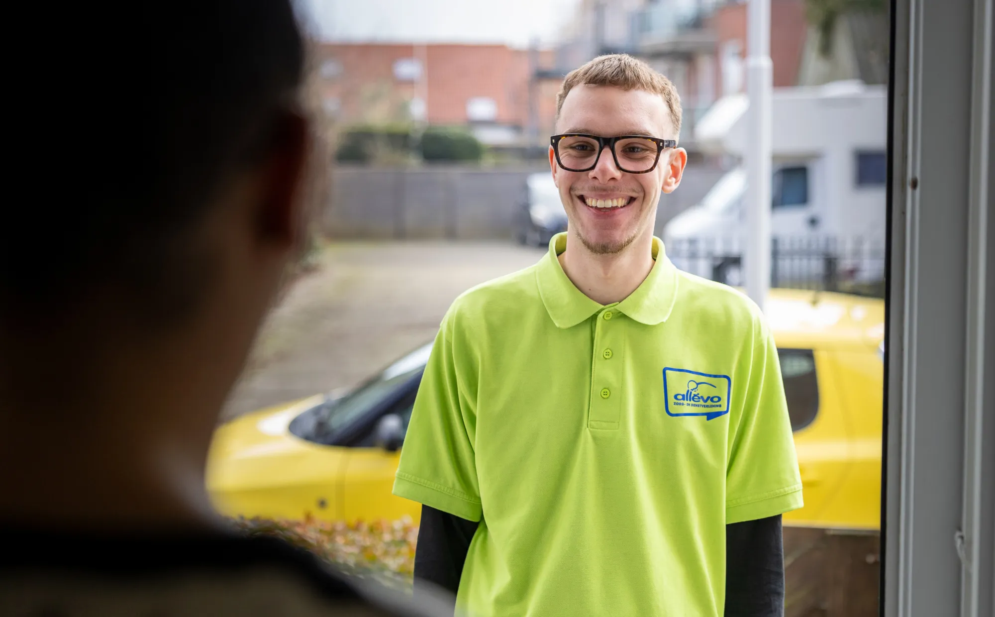 Medewerker aan de deur van cliënt om huishoudelijke taken te doen.