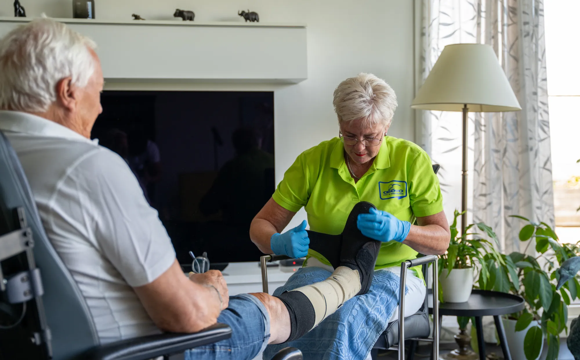 Medewerker van Allévo die handelingen doet bij een cliënt in de thuiszorg.